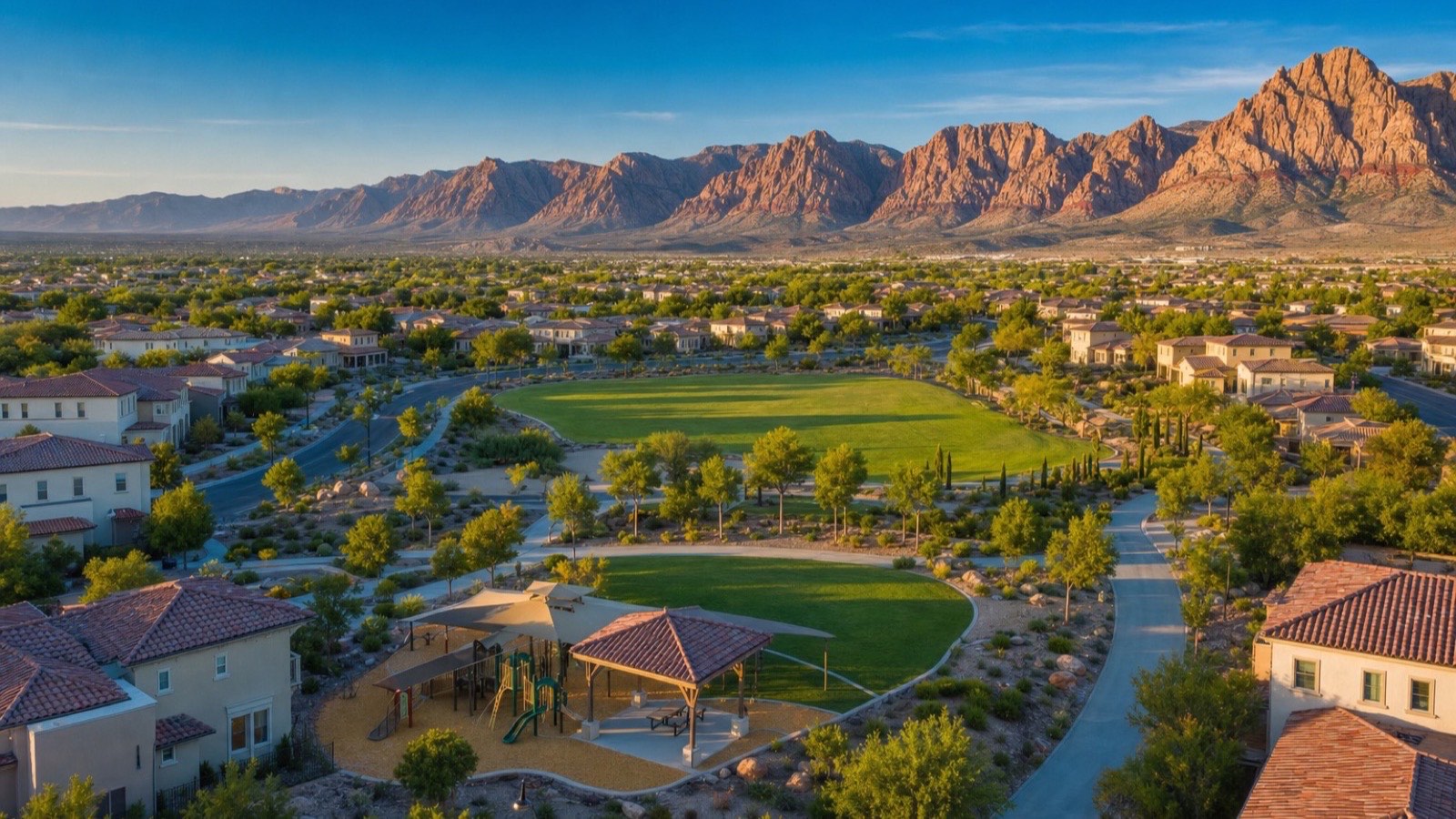 Aerial of a large park with sports lawns, a shade structure and a paved trail in The Paseos village of Summerlin West