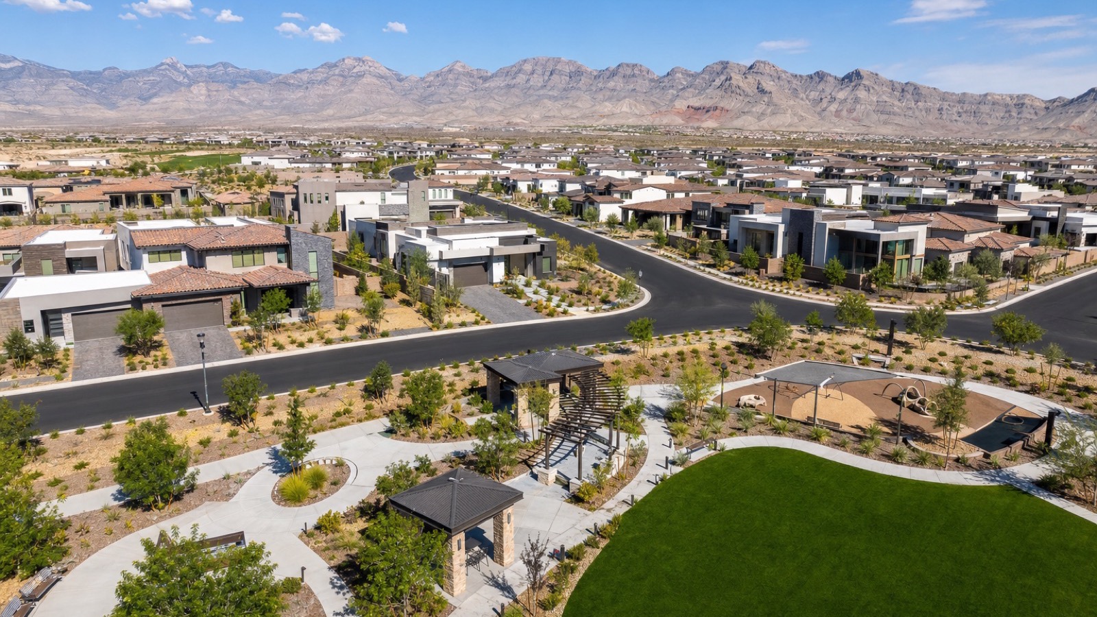New construction homes under way in a northwest Las Vegas neighborhood with framed houses, fresh streets and desert mountains behind