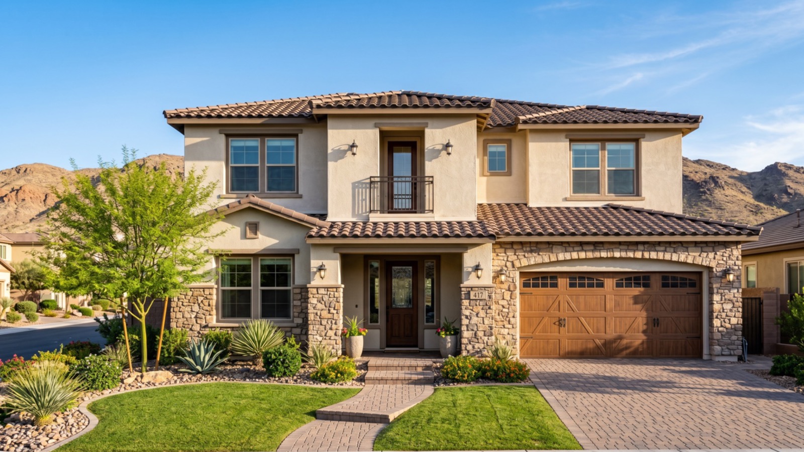Two-story Henderson home with a tile roof, stone accents and a wood-tone garage door against desert foothills