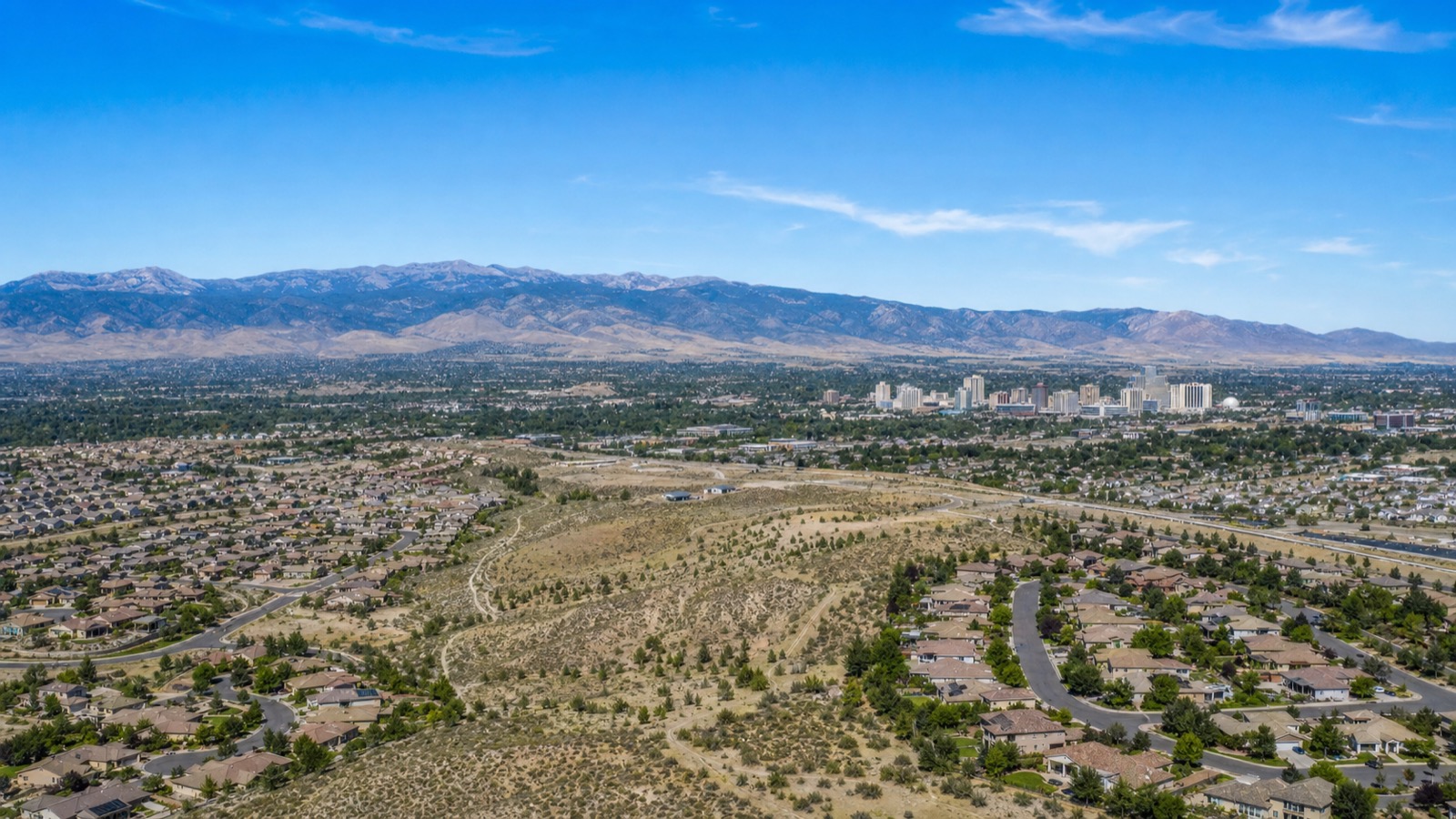 Wide aerial of the Truckee Meadows and Reno Nevada residential development below the Sierra Nevada range in 2026