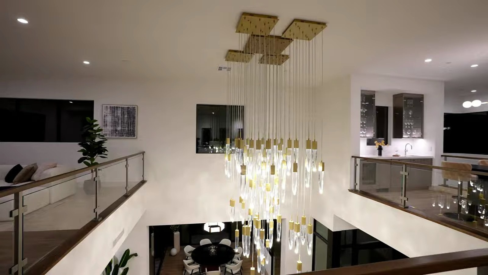 Upstairs catwalk at 521 Overlook Rim with a glass rail overlooking a crystal chandelier and the dining area below