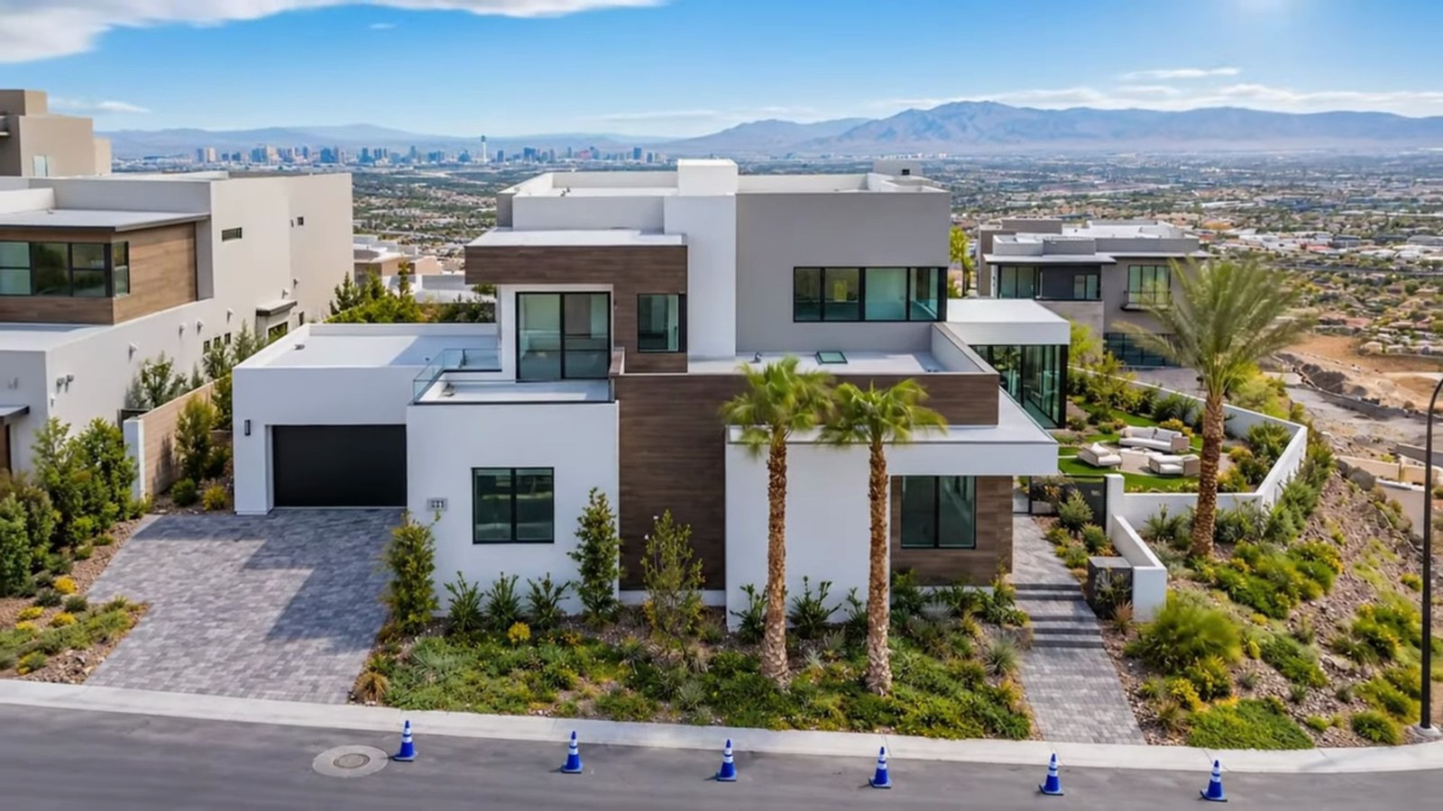 Drone view of 521 Overlook Rim, a modern two-story SkyVu home by Christopher Homes in MacDonald Highlands with the Las Vegas Strip and mountains behind it
