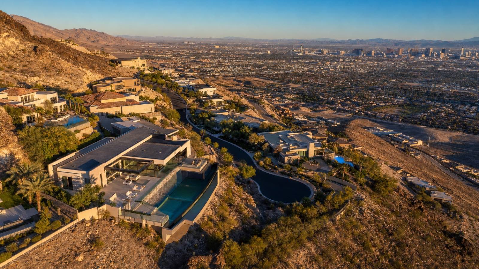 Illustration of hillside custom homes along a curving street, with natural desert slope between homesites and the Las Vegas Strip in the distance