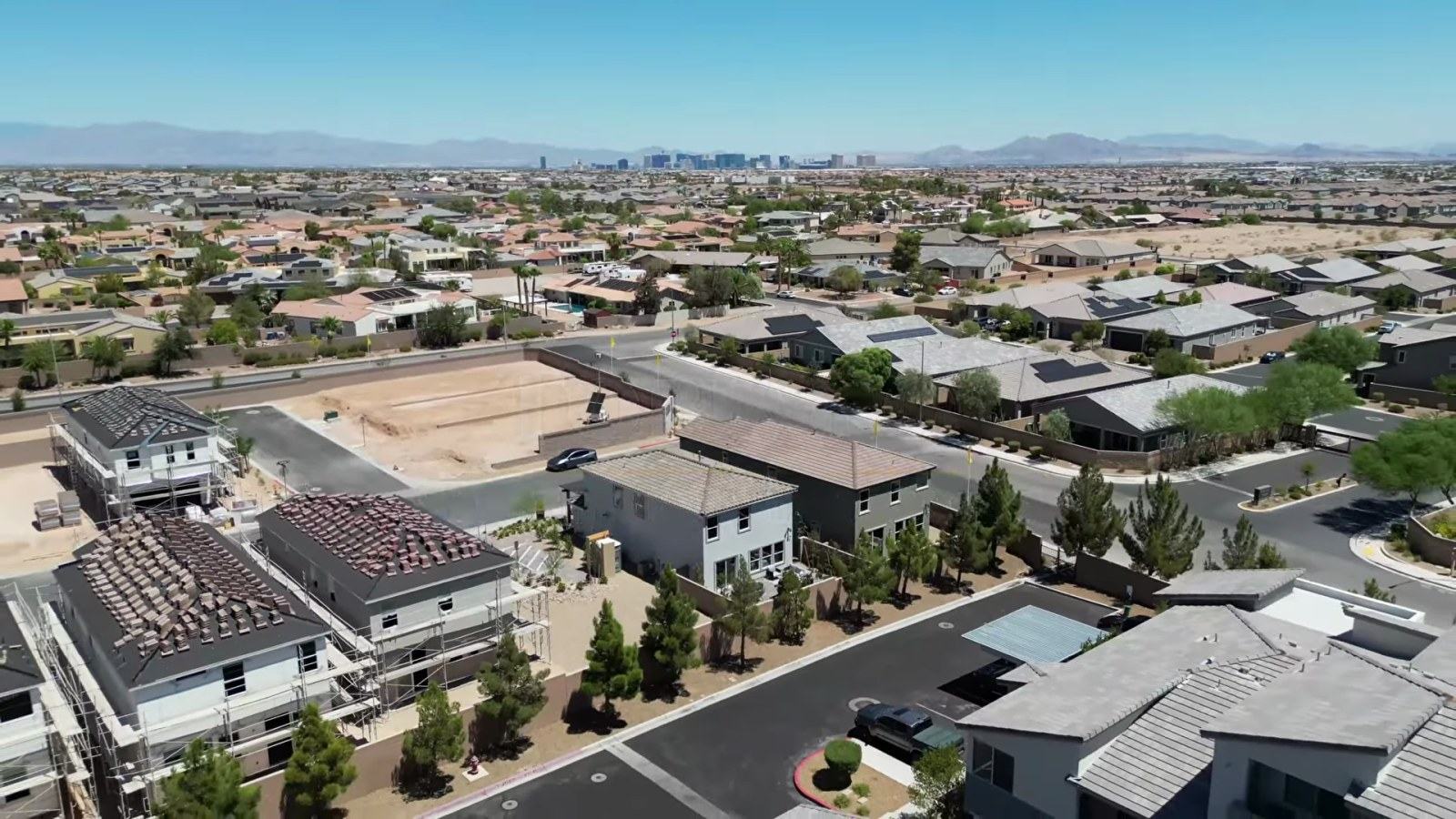Aerial view of the Tobiano neighborhood by KB Home in southwest Las Vegas with new two-story homes and the valley skyline