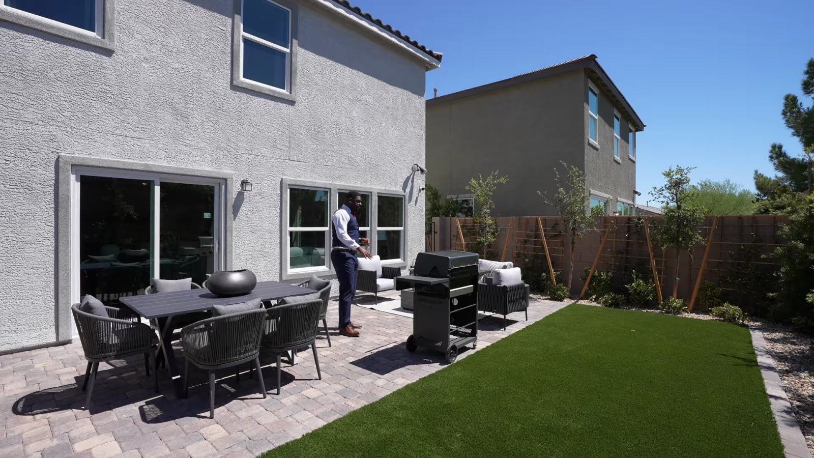 Finished model backyard at Tobiano with pavers, artificial turf and patio furniture, which KB Home delivers as dirt on a purchased Plan 1850