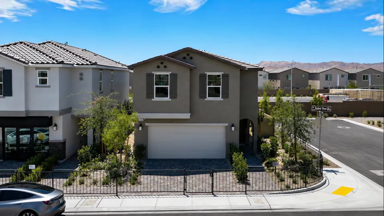 Front of the KB Home Plan 2069 model at Landings at Aven in southwest Las Vegas with a two-car garage, desert landscaping and the Spring Mountains behind
