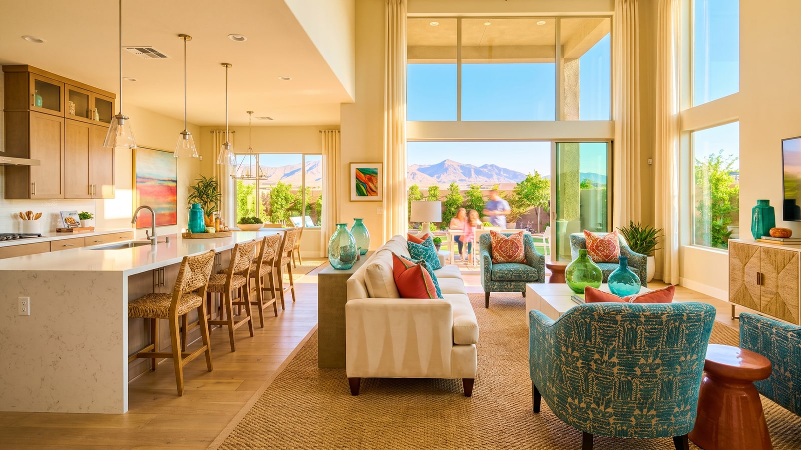 Staged Las Vegas luxury great room with lifestyle furnishing, open kitchen, and mountain views through floor-to-ceiling glass