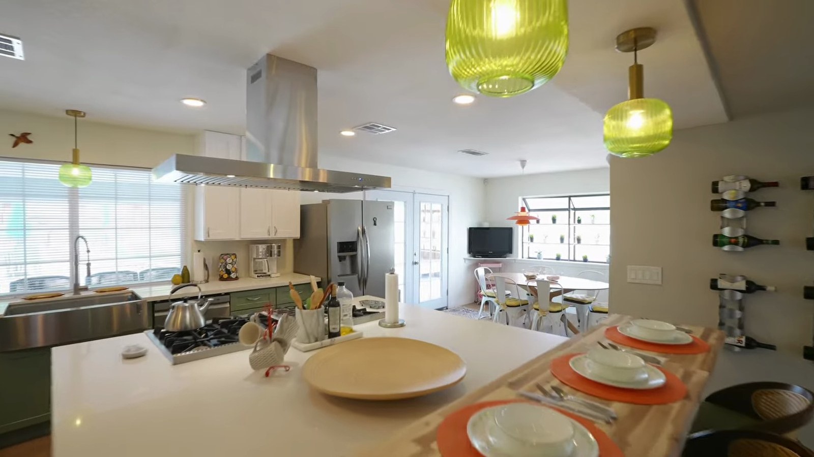Updated kitchen at 1400 Maria Elena Drive with a wood-topped island, stainless steel range hood, green pendant lights and a breakfast area