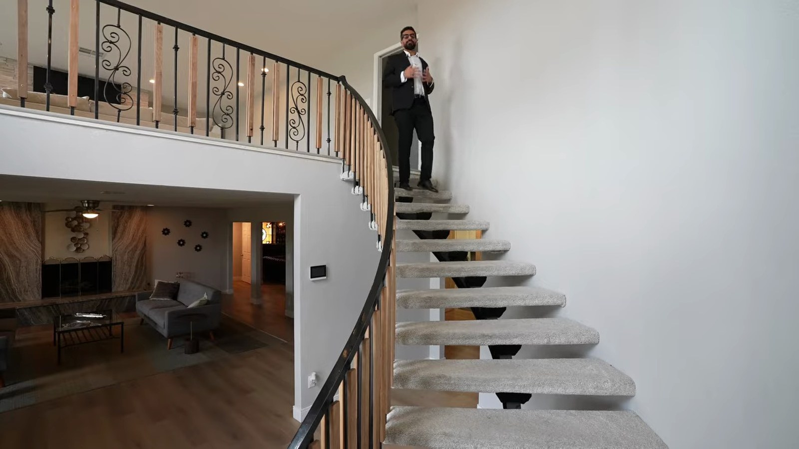 Spiral staircase with open treads and a wrought-iron rail in the two-story entry of the 1970 Mel Exber estate at 1400 Maria Elena Drive