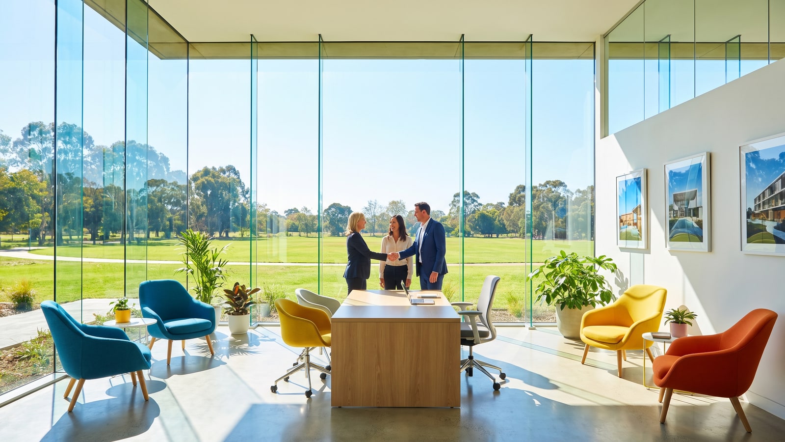 Nevada realtor shaking hands with a happy couple in a bright modern office with floor-to-ceiling windows