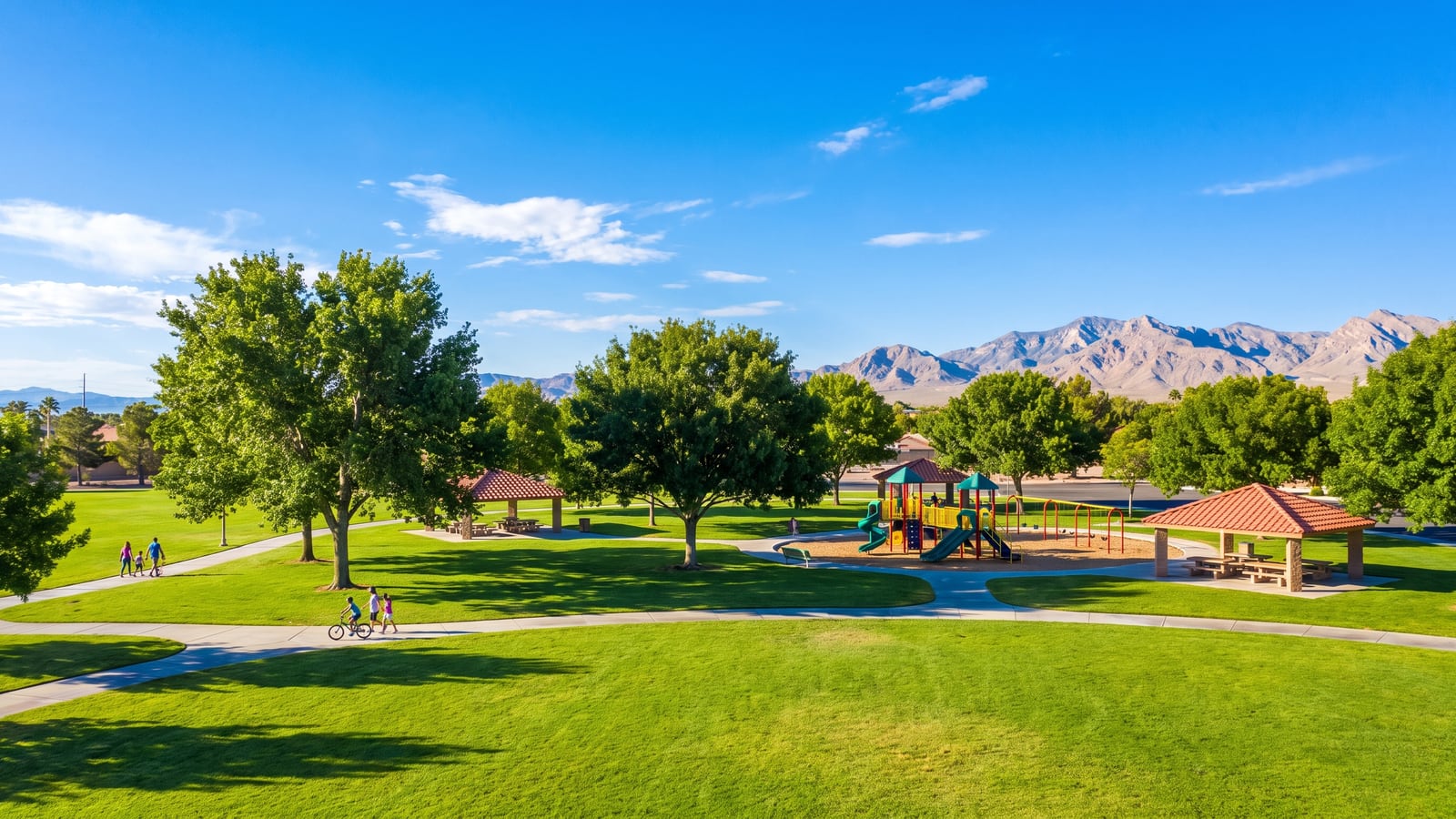 Broad green lawns and mature shade trees at Craig Ranch Regional Park with families using the walking paths
