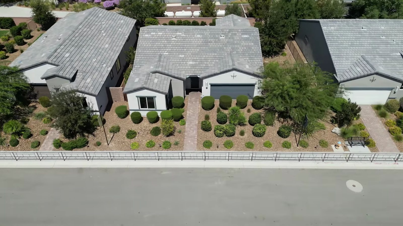 Overhead aerial of three single-story homes with desert landscaping on compact subdivision lots in Ovation at Mountain Falls, Pahrump