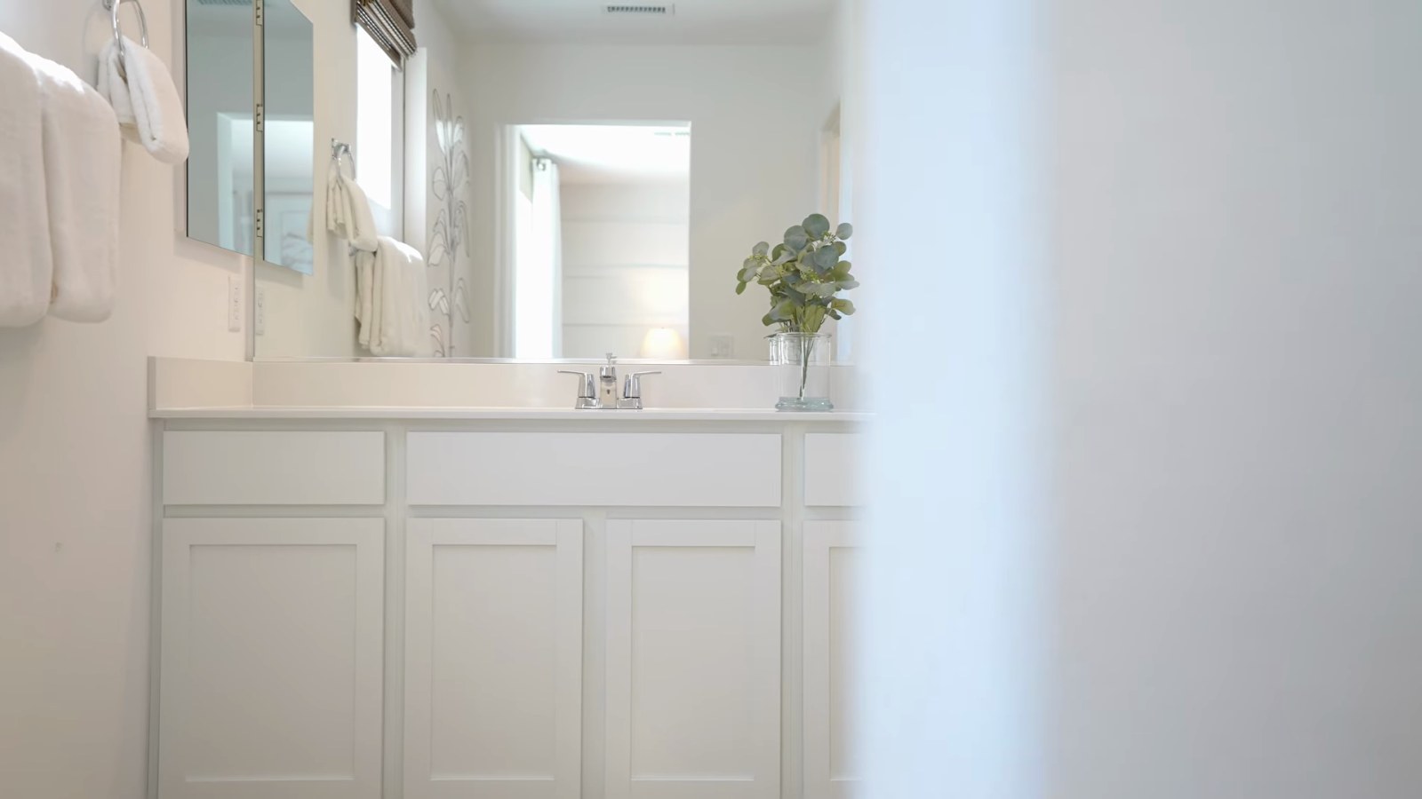 Primary bathroom vanity in the Pulte Branton model at Dalea at Aries with white cabinets, a single sink and a window