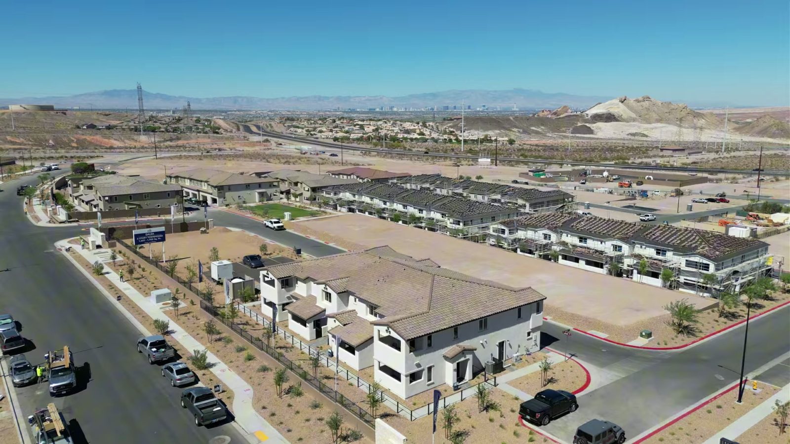 Aerial view of the first Dalea at Aries townhome buildings in east Henderson with graded lots, Lake Mead Parkway traffic and mountains on the horizon