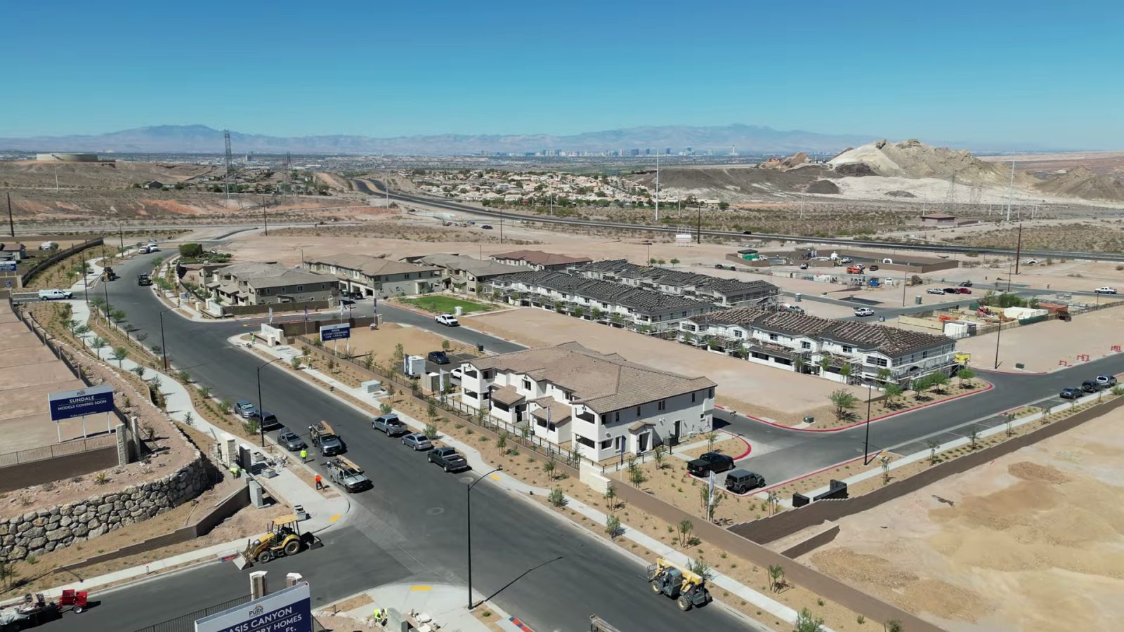 Aerial view of the first Dalea at Aries townhome buildings and graded lots in east Henderson with the Las Vegas valley and mountains beyond