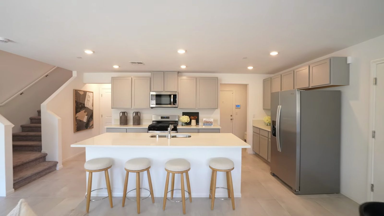 Pulte Danbury model kitchen at Dalea at Aries with a quartz island, four stools, gray shaker cabinets and stainless appliances
