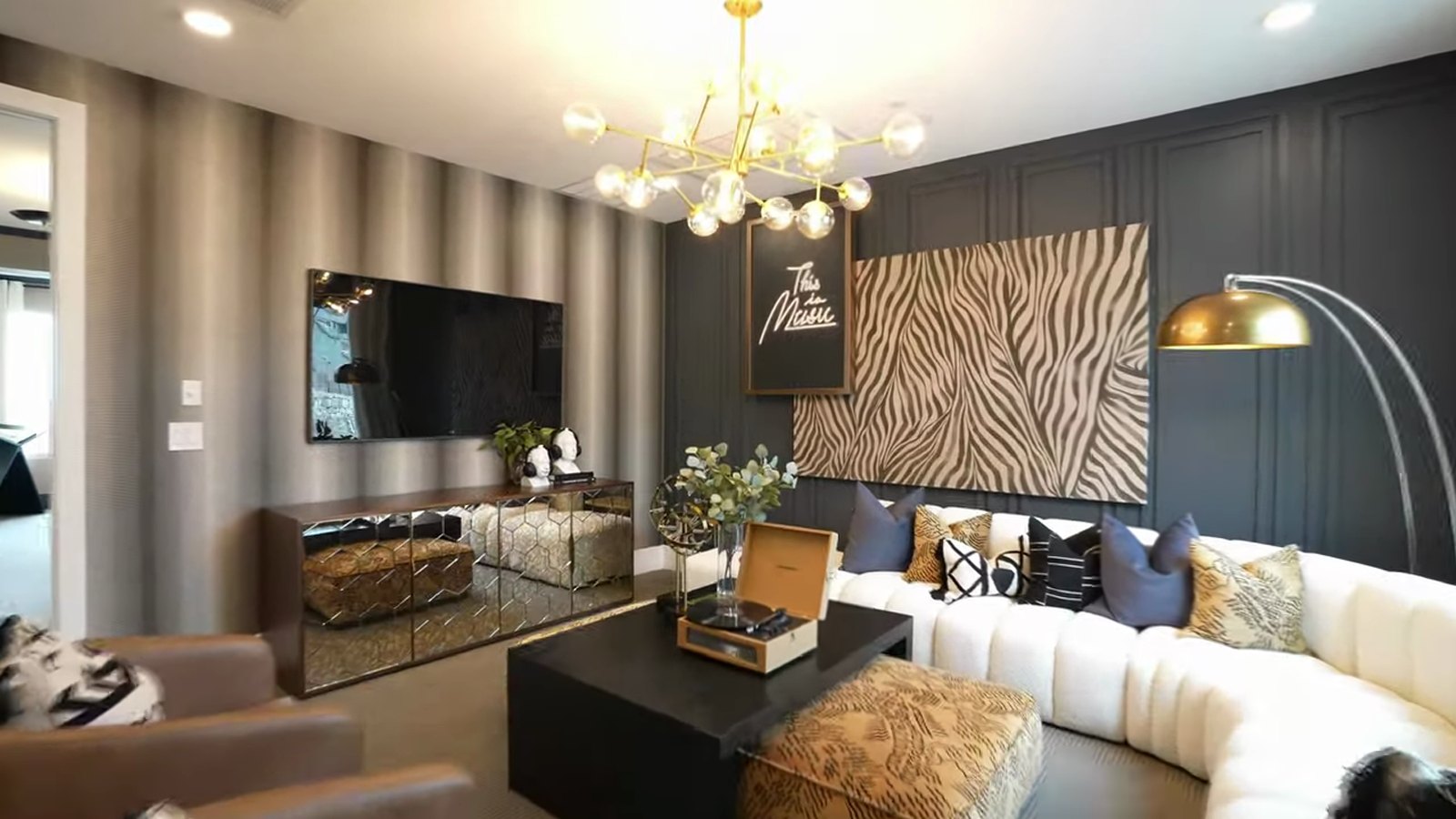Upstairs loft in the Pulte Tivoli model at Brantley in Summerlin with a curved sectional, media wall and brass chandelier