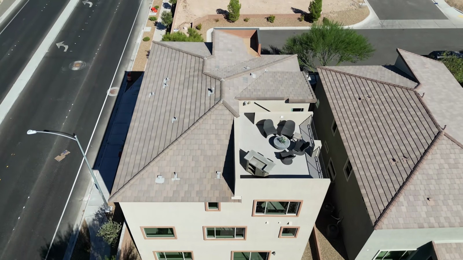 Aerial view of the White Pine model at Delamar showing a furnished rooftop deck set into the tile roof of a three-story home