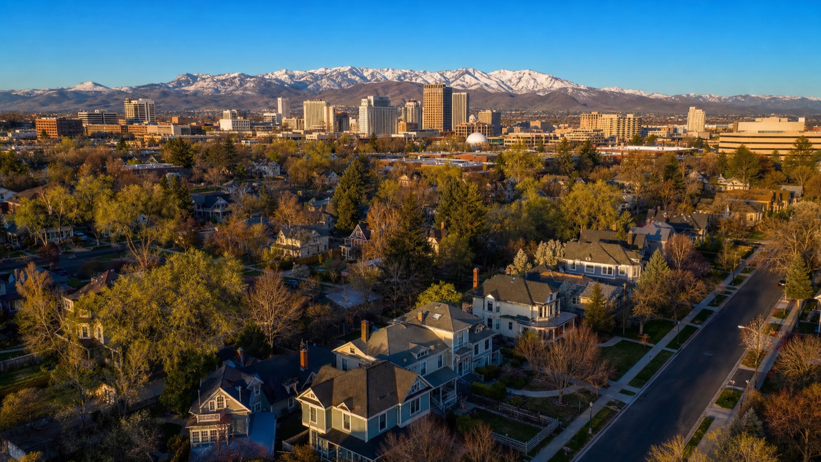 Aerial view of the historic homes of the University district in Reno with the downtown skyline and snow-capped mountains behind