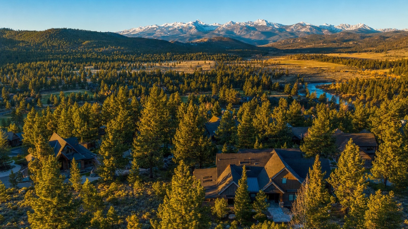 Aerial view of mountain homes among pines in Verdi west of Reno with the snow-capped Sierra crest at sunrise