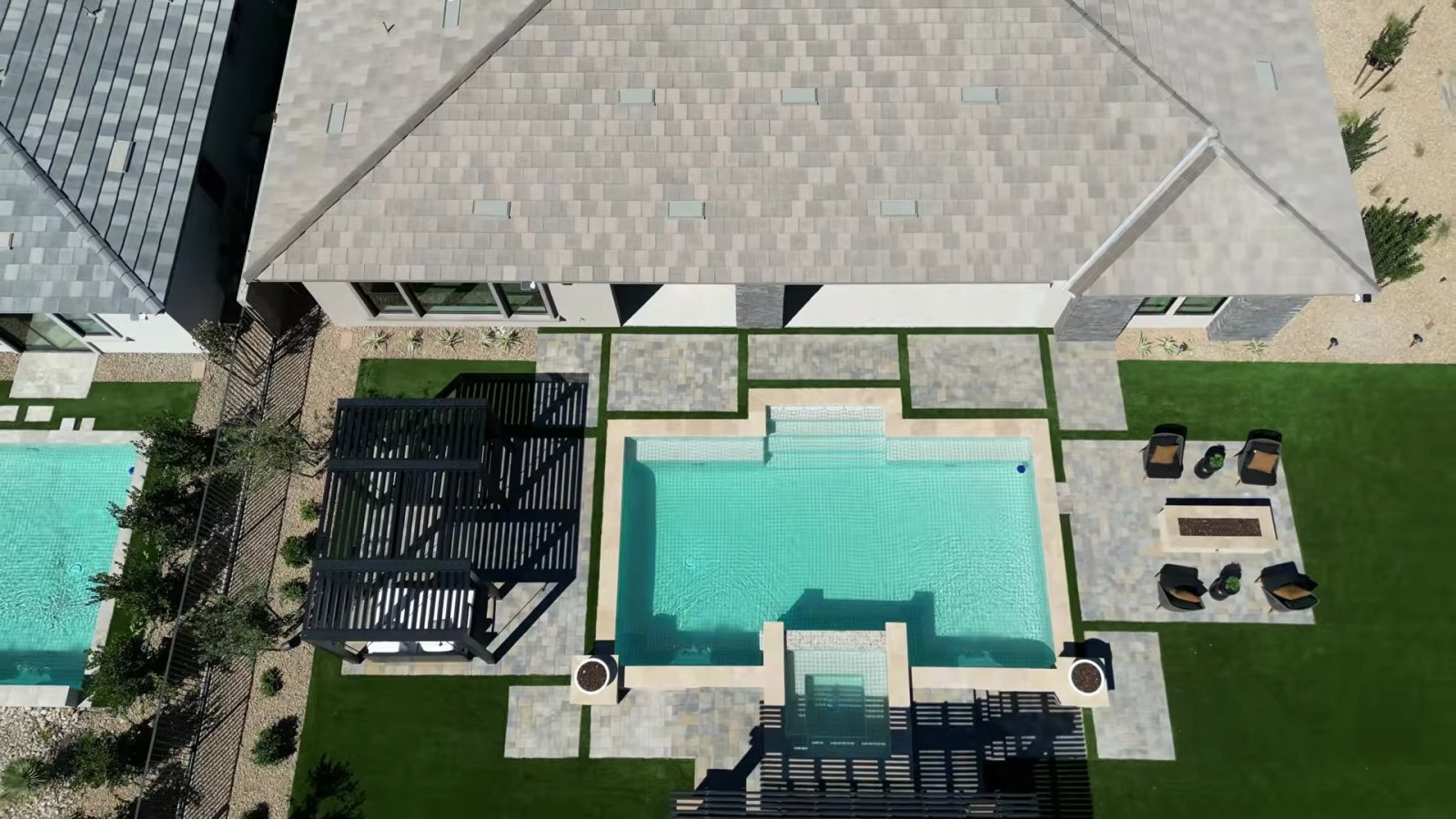 Aerial view of the Rowan model backyard at Cactus Bloom with a pool, spa, pergolas, fire pit seating and artificial turf