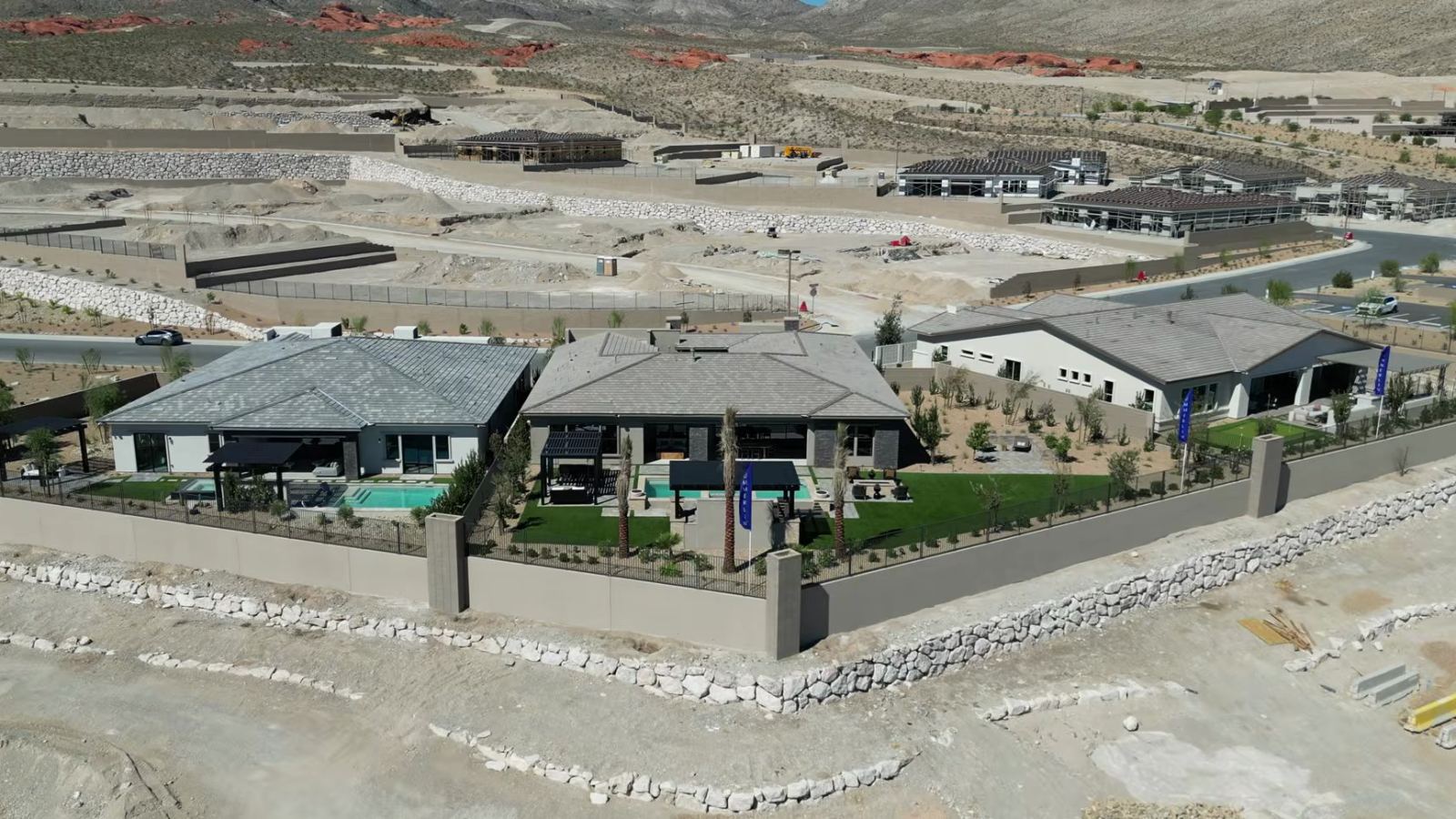 Aerial view of the Richmond American model homes at Cactus Bloom in Summerlin's La Madre Peaks village, with graded homesites and red sandstone foothills behind