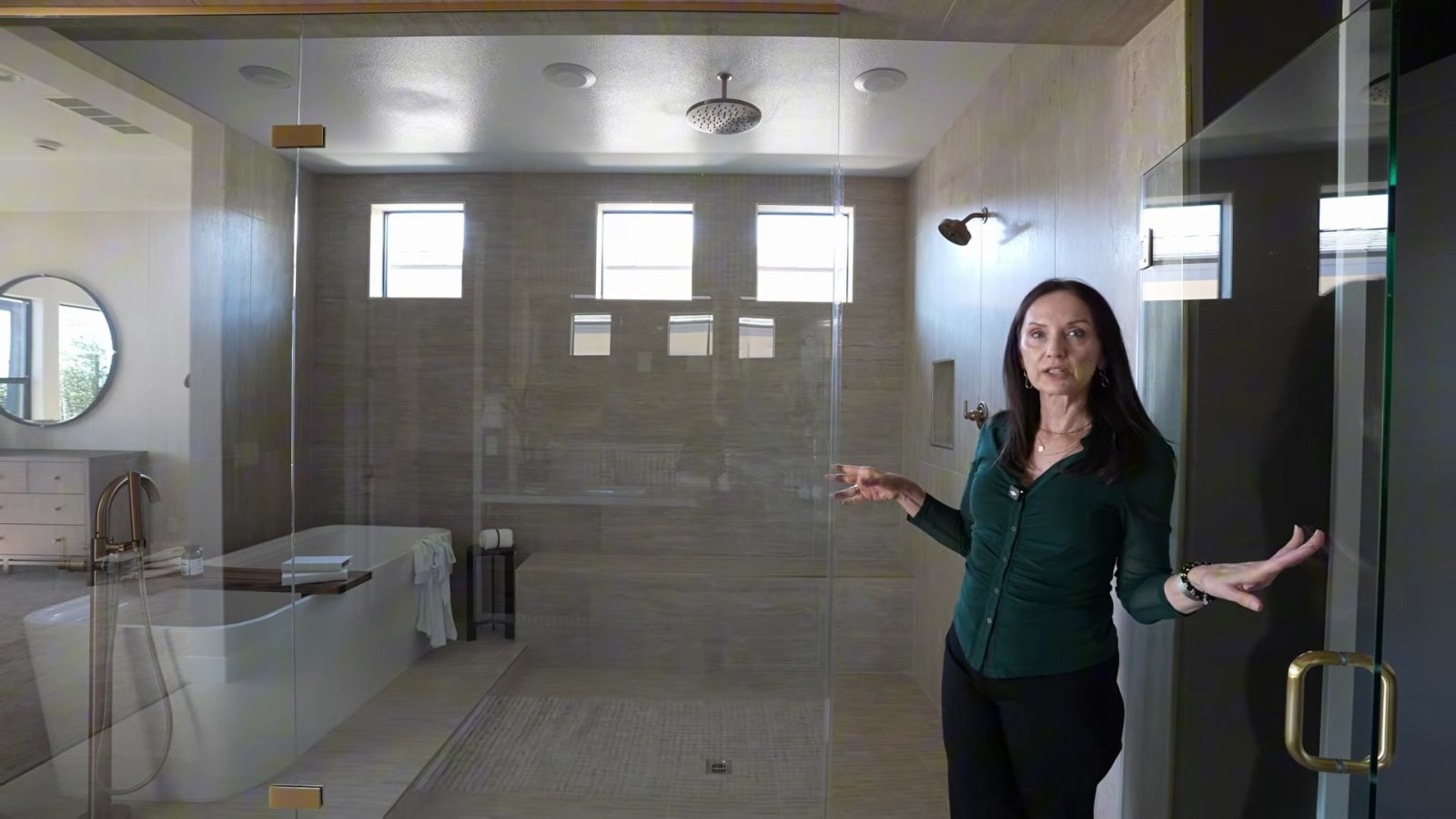 Primary bath wet area in the Richmond American Rowan model with a freestanding tub and rain shower behind a glass enclosure