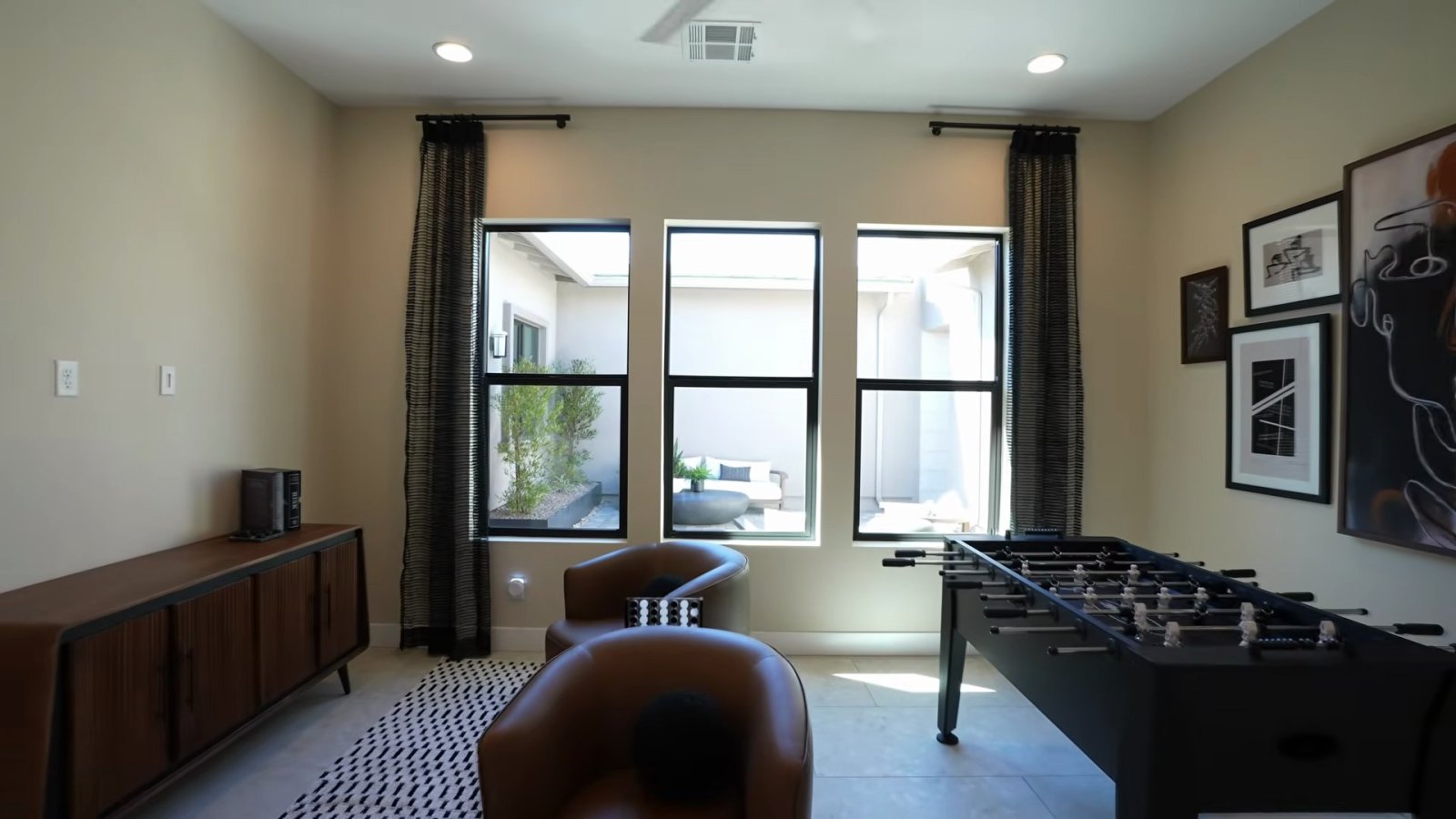 Teen room lounge in the Richmond American Rowan model staged with a foosball table, swivel chairs and framed art