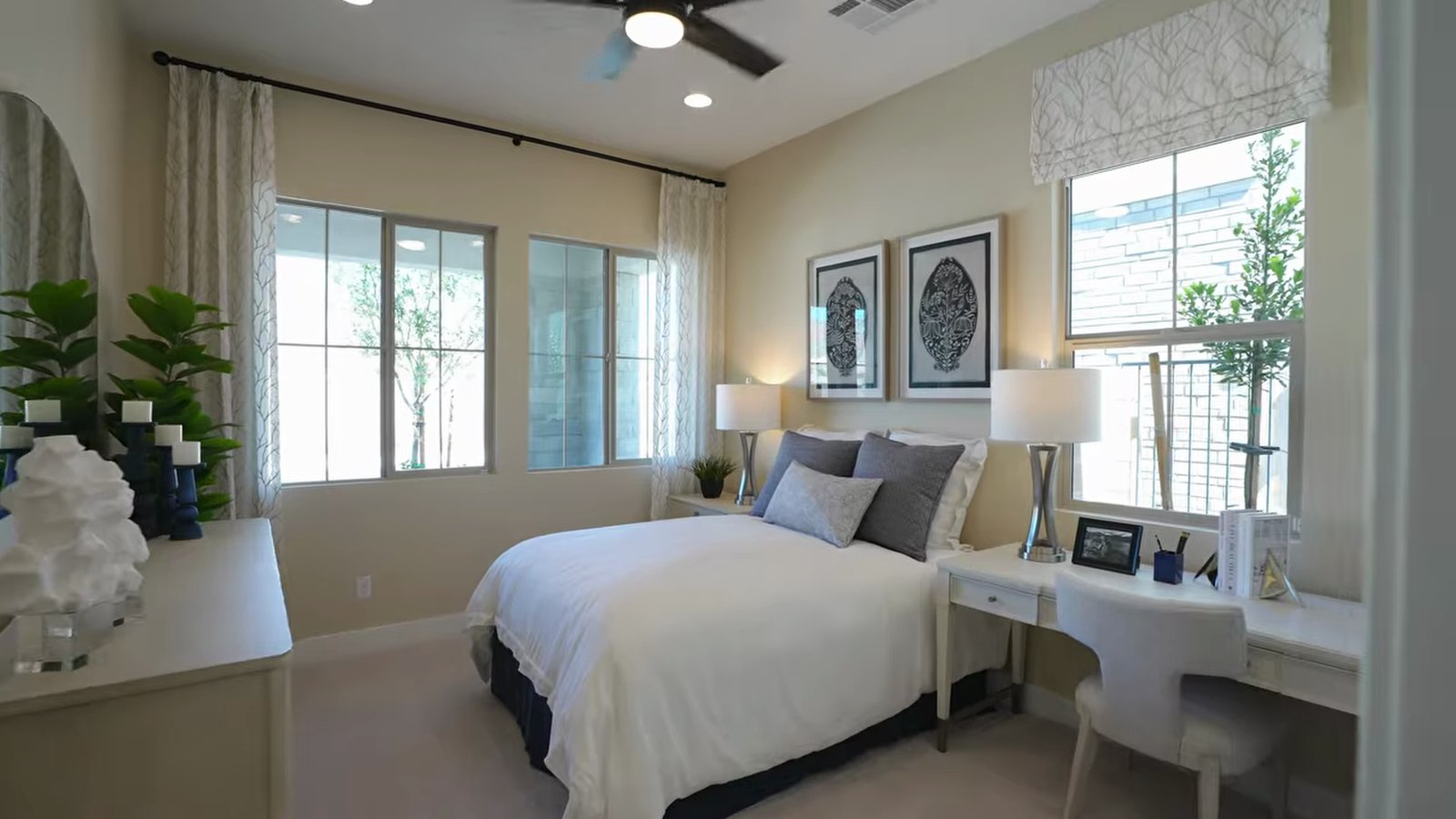 Downstairs junior suite in the Richmond American Teton model at Primrose Park with a bed, desk and two windows