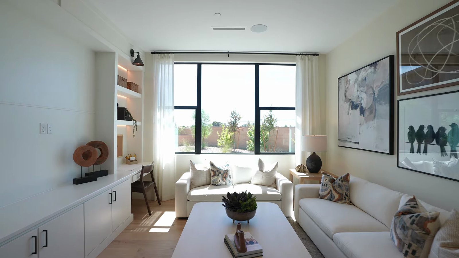 Bonus room in the Shawood Kagari model's secondary bedroom wing, furnished as a sitting room with built-in shelving and a desk