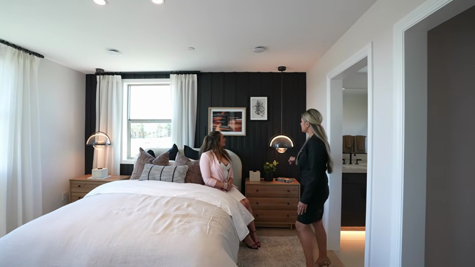 Furnished suite above the detached garage at the Shawood Towa model with a king bed, accent wall and large windows