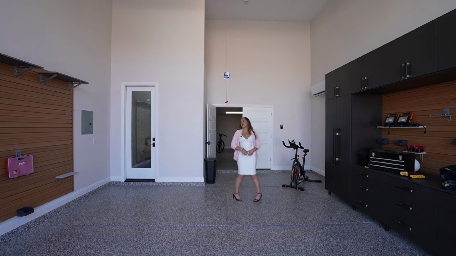 Detached toy garage at the Shawood Towa model in Northwest Las Vegas with a workshop wall, storage cabinets and an exercise bike