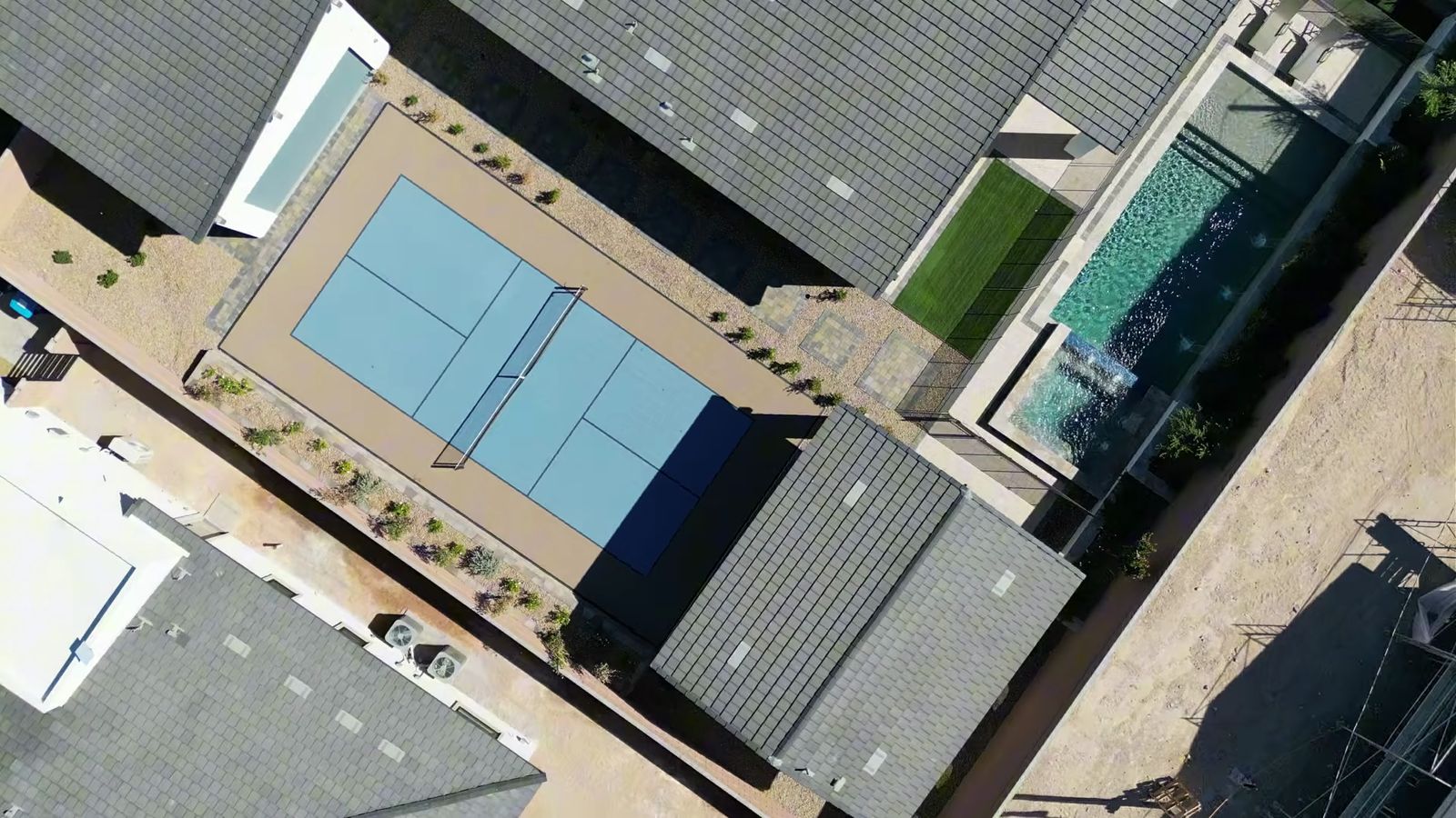 Overhead drone view of the Quartet model backyard at Signature Estates with a pickleball court, a pool and spa, and artificial turf