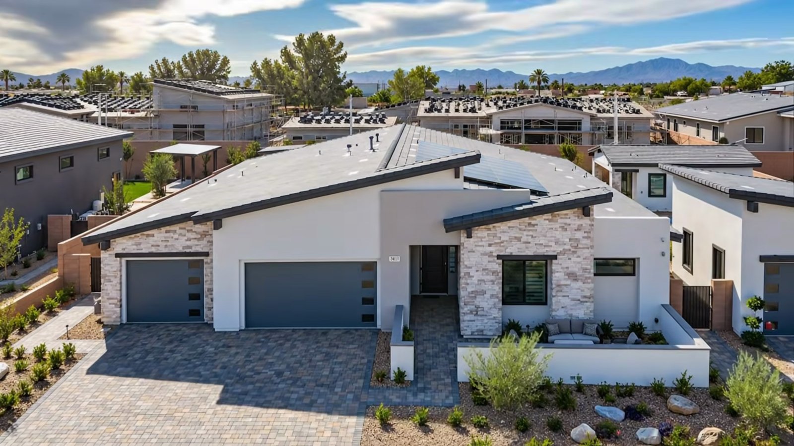 Aerial view of the single-story Quartet model at Signature Estates in Henderson with a paver driveway, two garage doors and a walled front courtyard