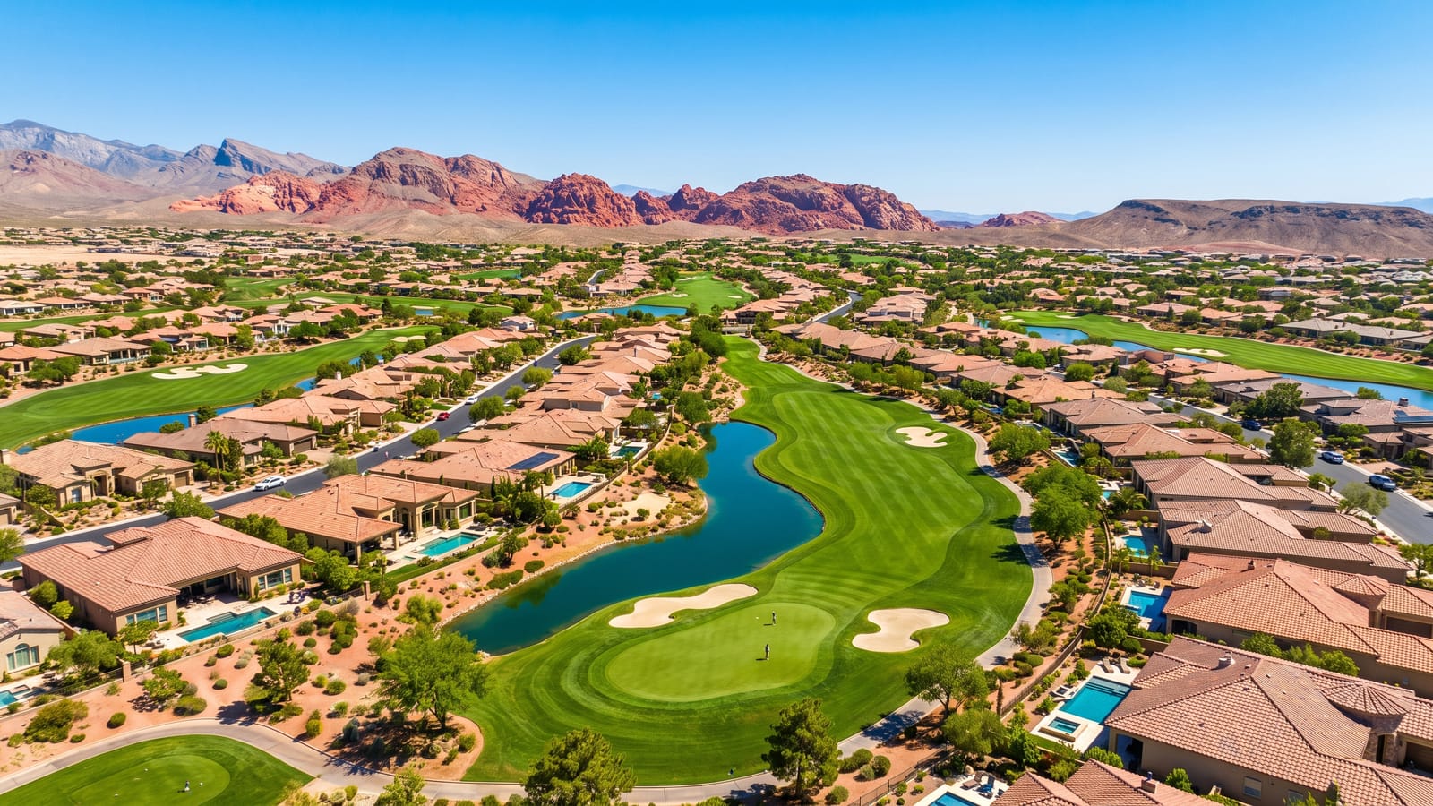 Aerial view of a Summerlin golf community with fairways winding between luxury tile-roof homes near TPC Las Vegas