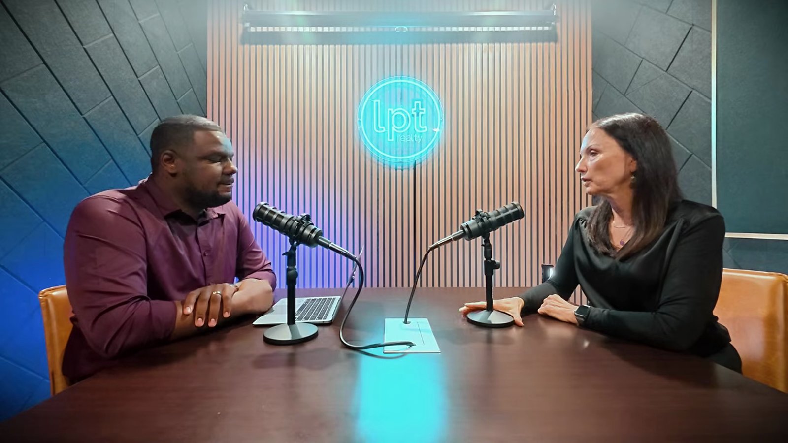 Daniel Pittman and Stacey Tyler of Nevada Real Estate Group talking across a table in the Las Vegas Playbook studio