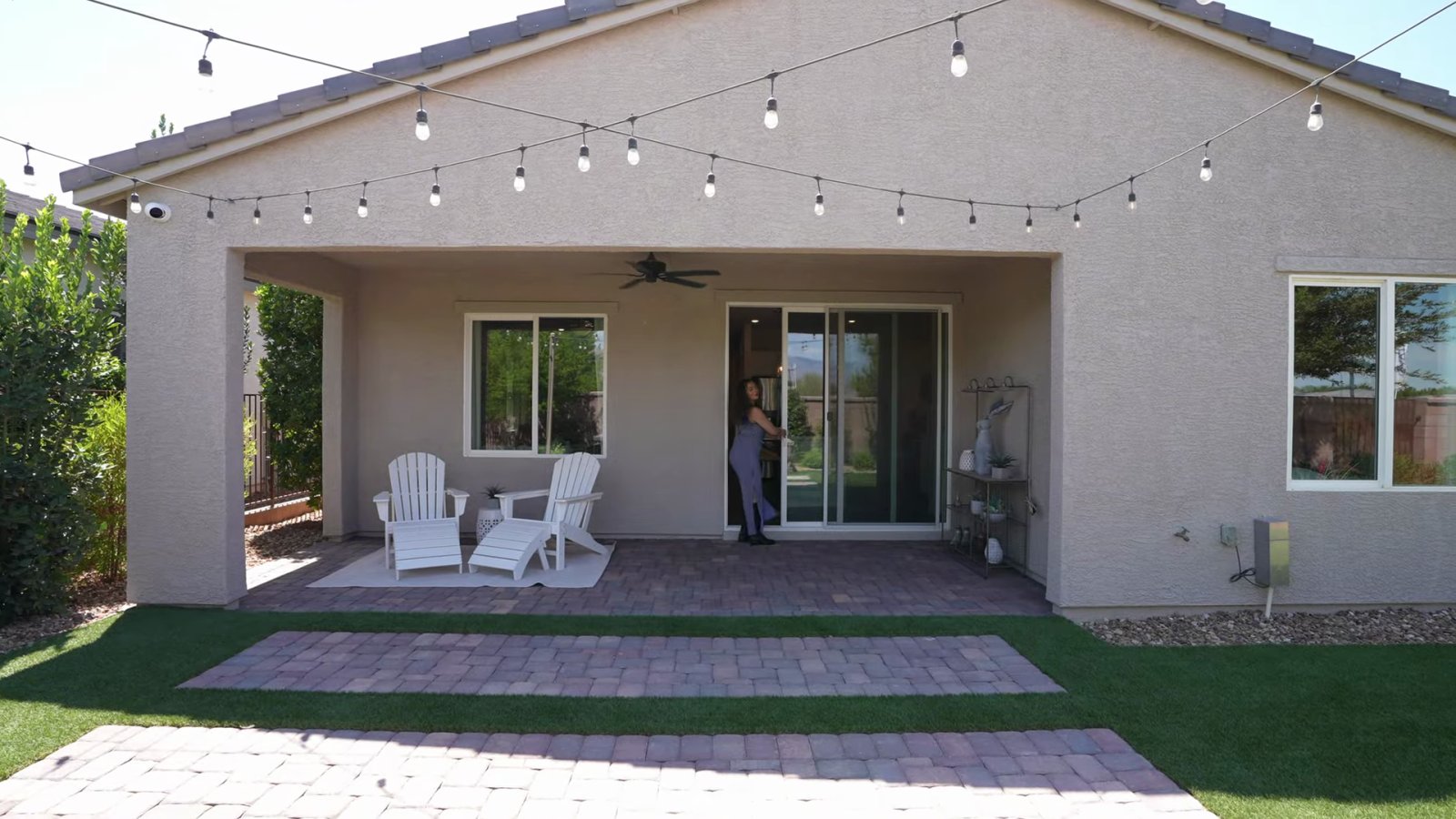 Daffodil model backyard at Ovation at Mountain Falls with a covered patio, string lights, pavers and artificial turf that a purchased home does not include