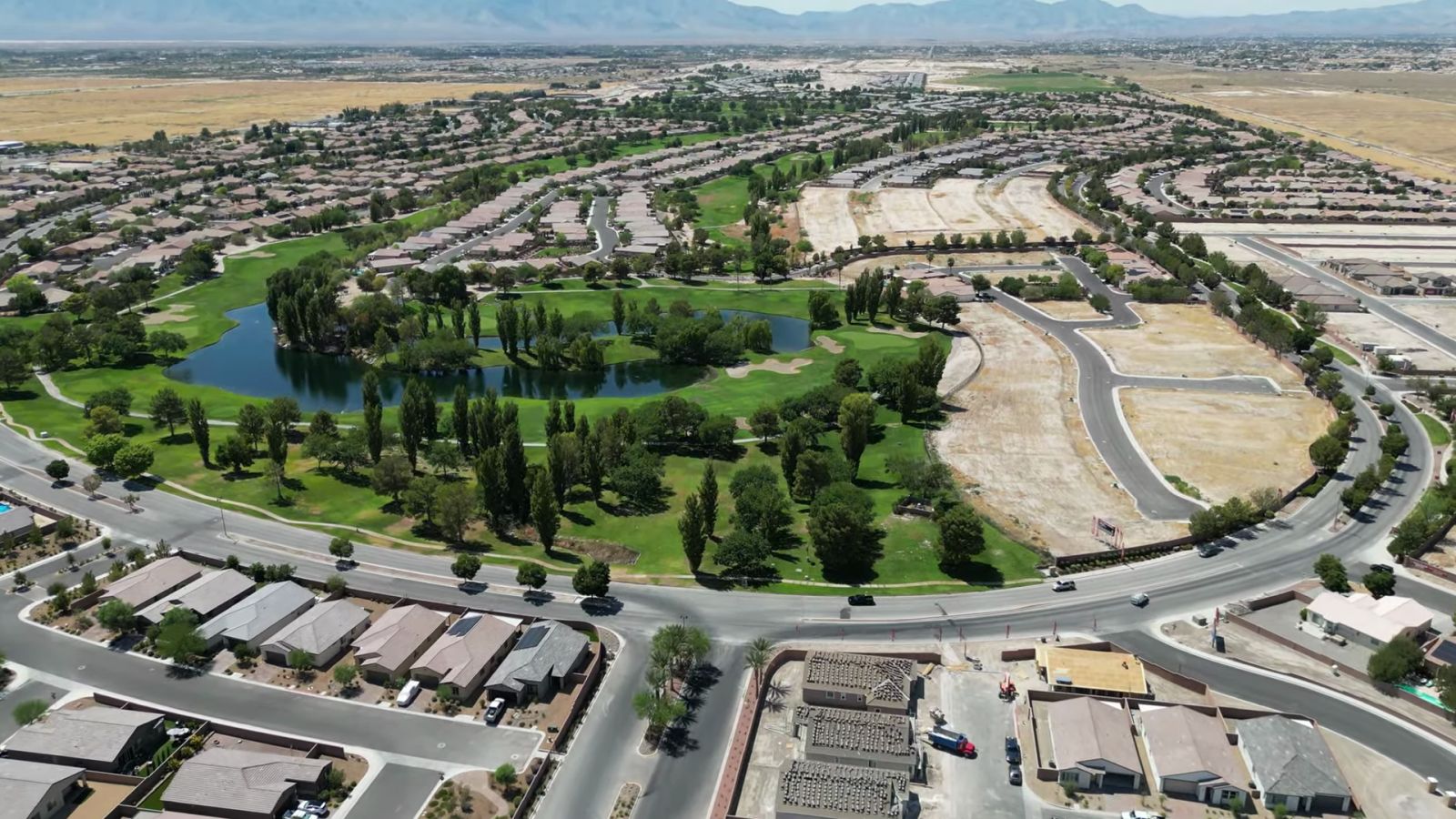 Aerial view of the Mountain Falls golf course and lake in Pahrump, Nevada, with neighborhoods and graded homesites around the fairways