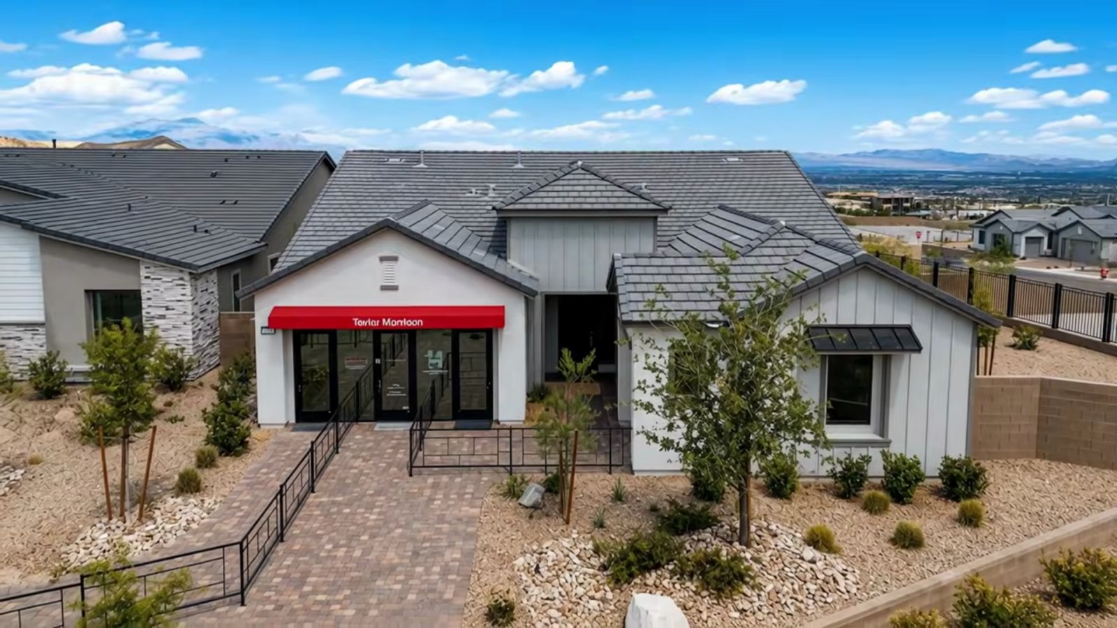 Taylor Morrison Heritage model at Ashland in Summerlin seen from a drone, a single-story home with a gabled roof, paver walkway and desert landscaping