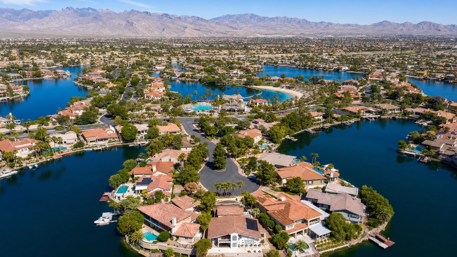 Las Vegas waterfront residential context showing lakefront-frontage homes with private boat dock infrastructure and the desert mountain backdrop