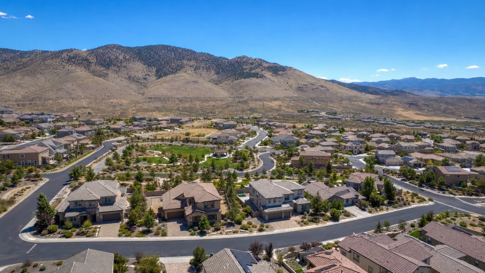 Aerial view of newer attached and single-family homes in Reno's North Valleys beneath brown foothills