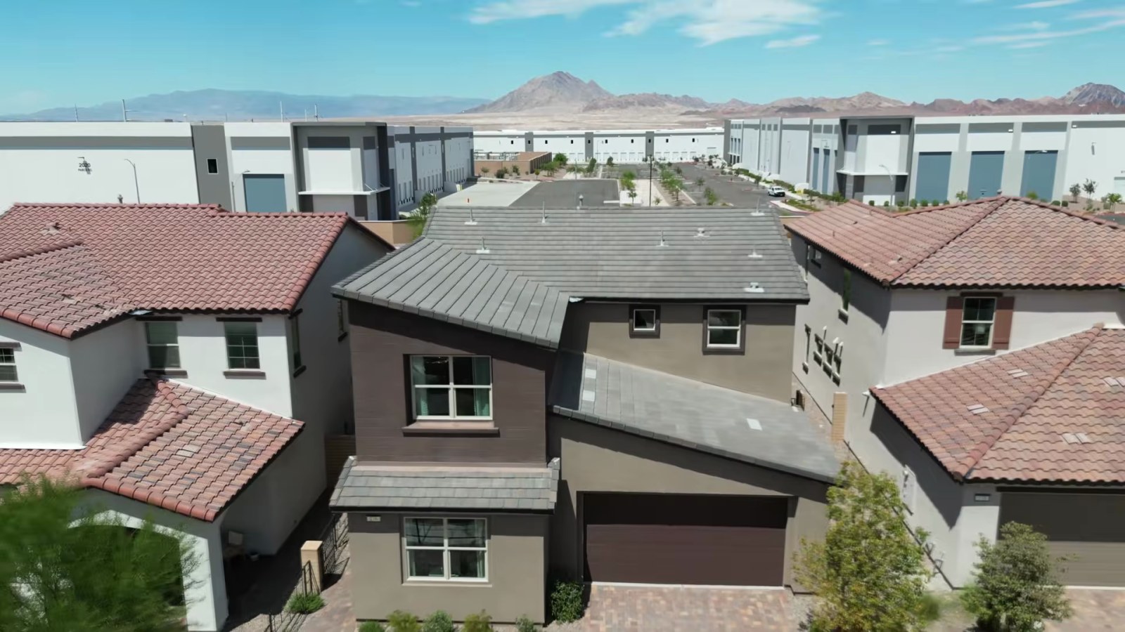 Aerial view of the Woodside Oakley model at Ashwood at Cadence in Henderson with industrial buildings and desert mountains behind it