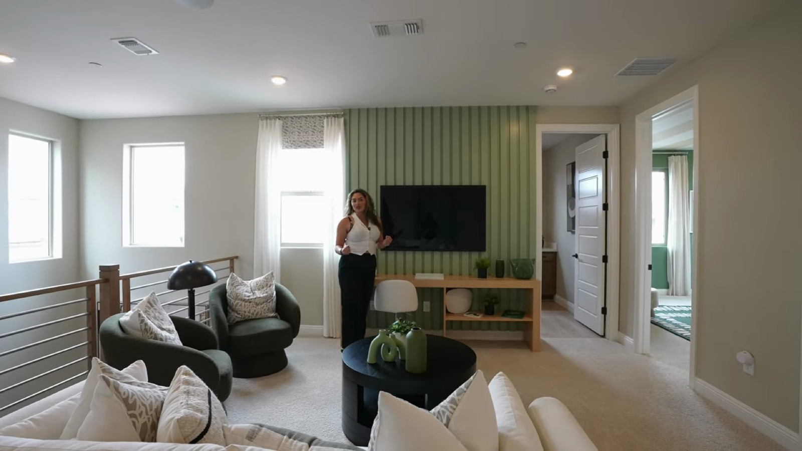 Oakley upstairs loft at Lyra at Sunstone staged with a sofa, lounge chairs and a television on a green accent wall