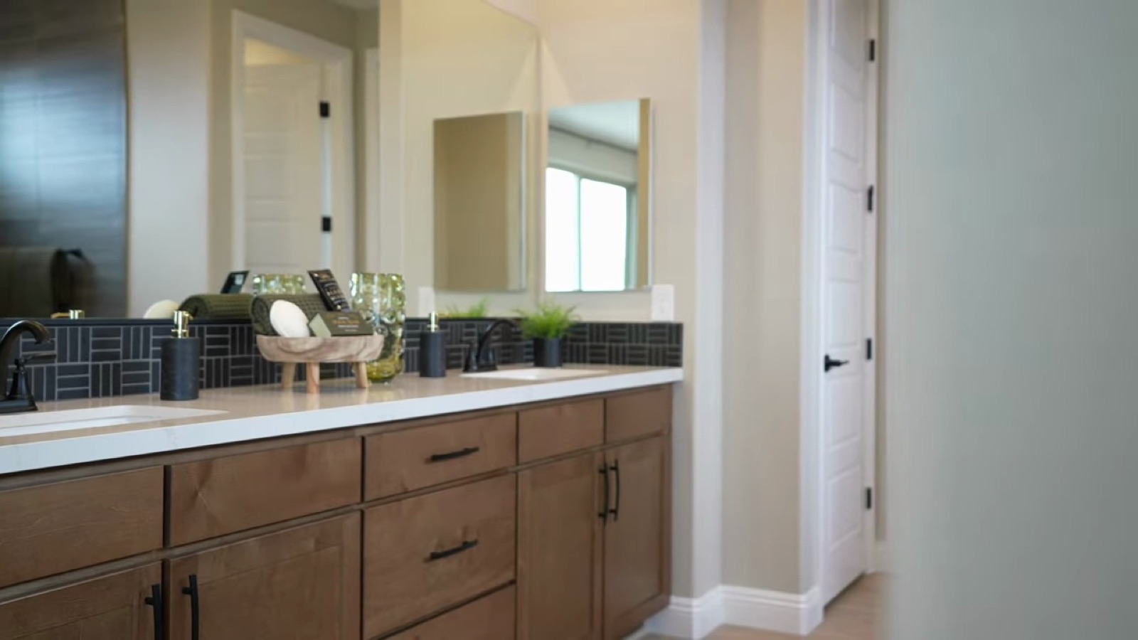 Oakley primary bathroom with a double vanity, wood cabinets and a tiled walk-in shower