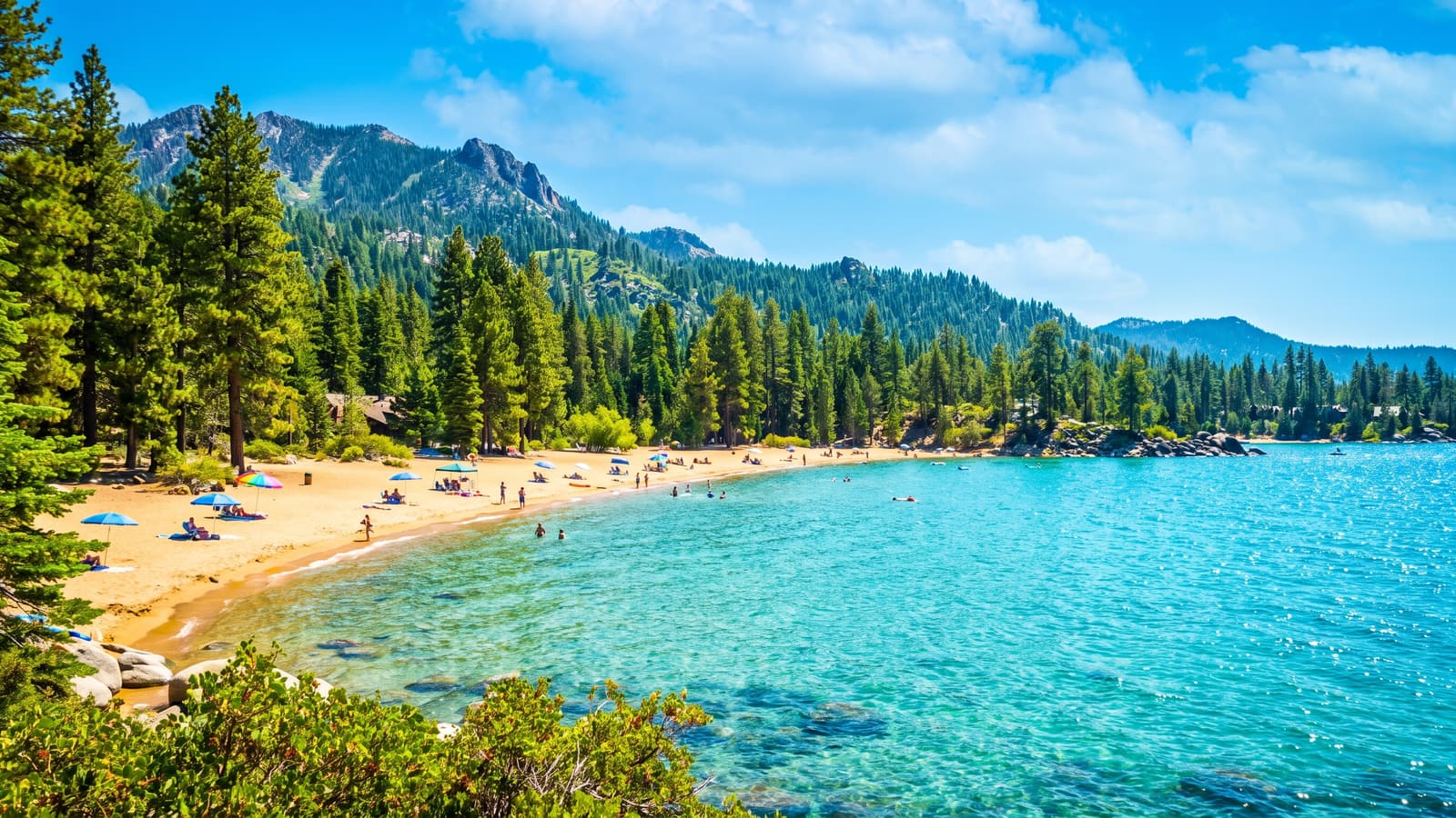 Bright sandy Zephyr Cove beach on the Nevada shore of Lake Tahoe on a sunny summer day with turquoise water and pine forest, in Douglas County's capped Vacation Home Rental territory